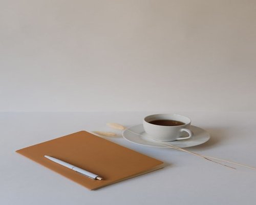A cup of coffee next to a notepad showing break time